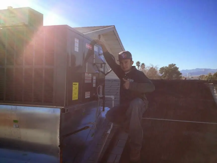 HVAC technician performing AC Tune-Up on a rooftop unit in Hanover